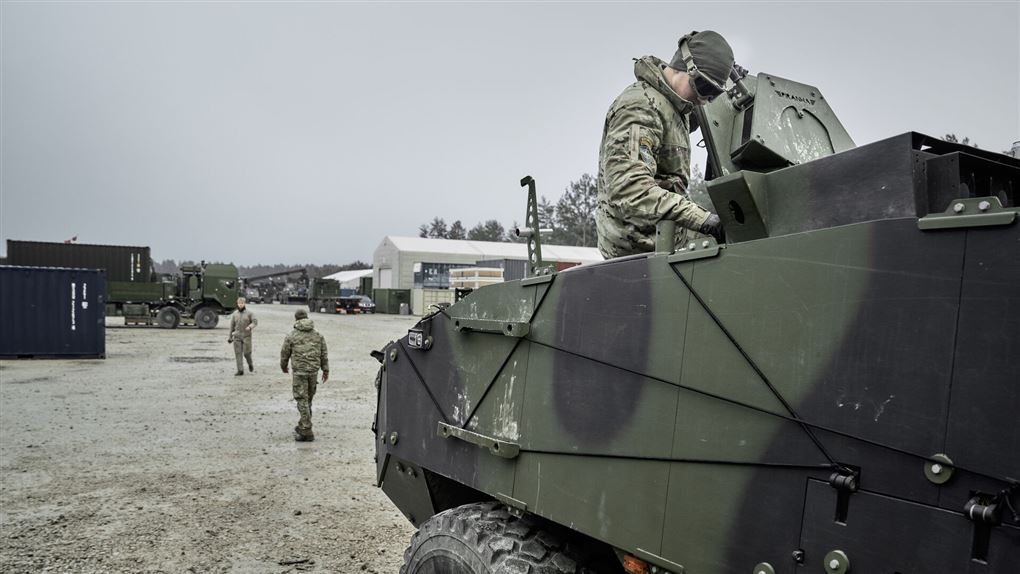 et militært køretøj og nogle danske soldater