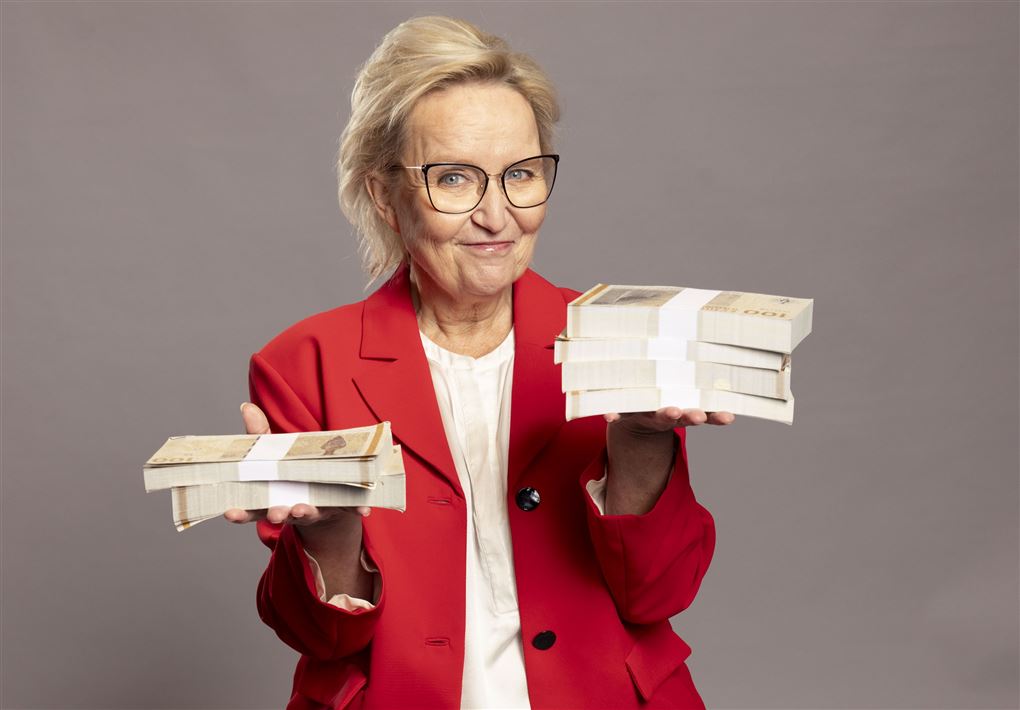 Kvinde holde en bunke penge i hver hånd