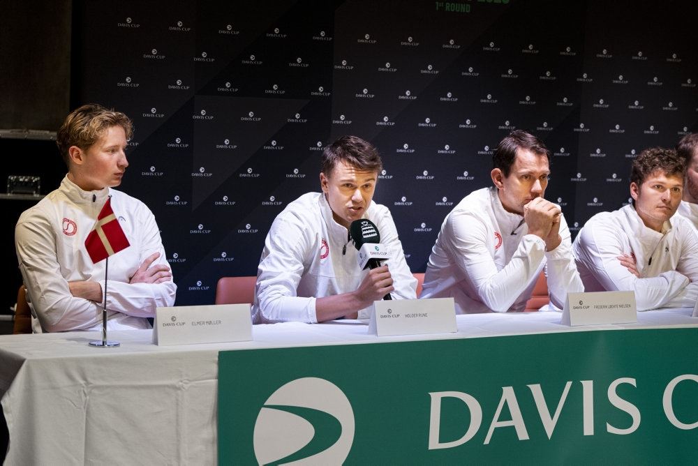 Fire personer på podium til pressemøde