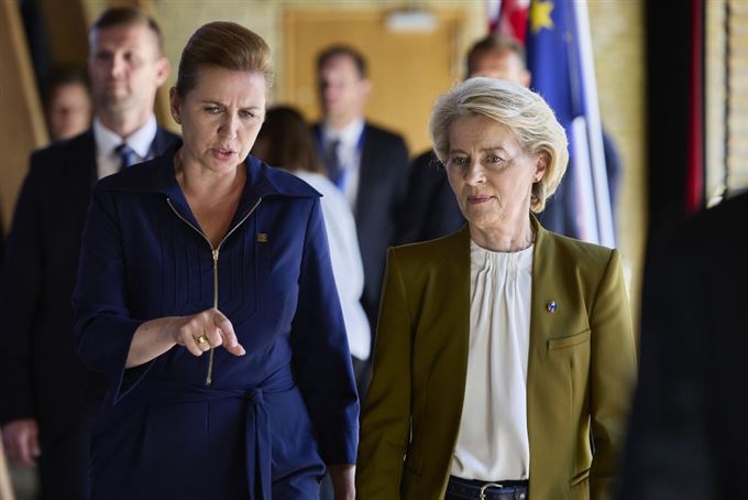 to kvinder kommer gående og snakkende